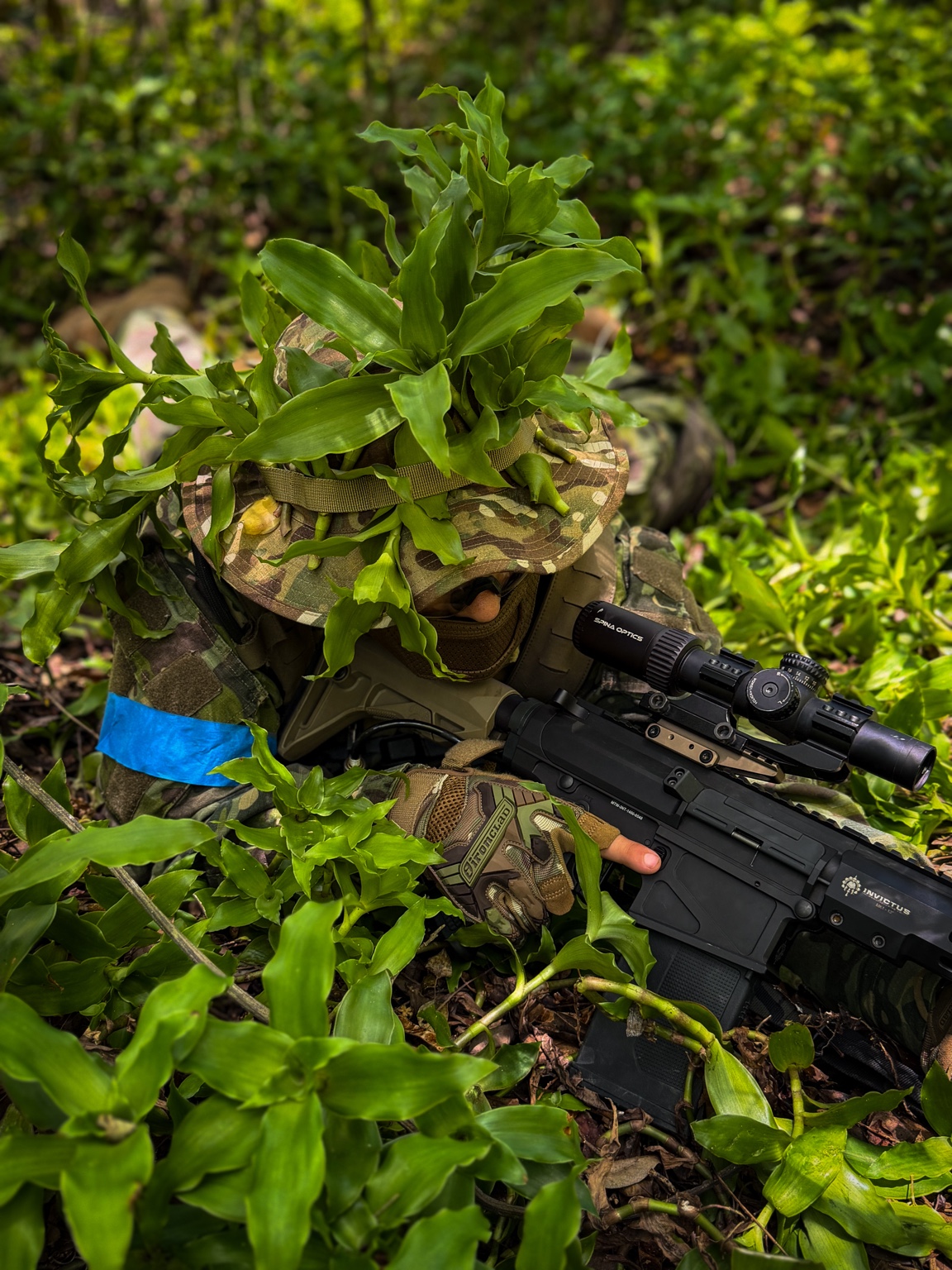 Jugador de airsoft camuflado entre vegetación