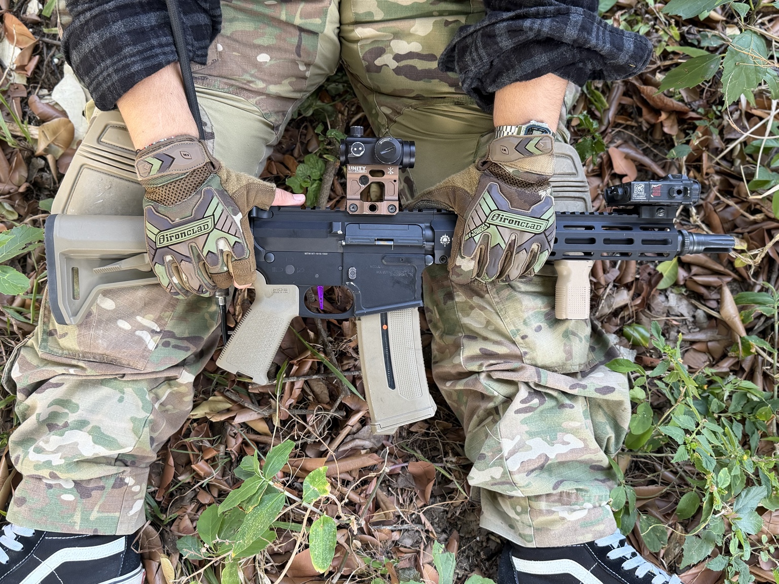 Réplica de airsoft y guantes sobre uniforme de camuflaje
