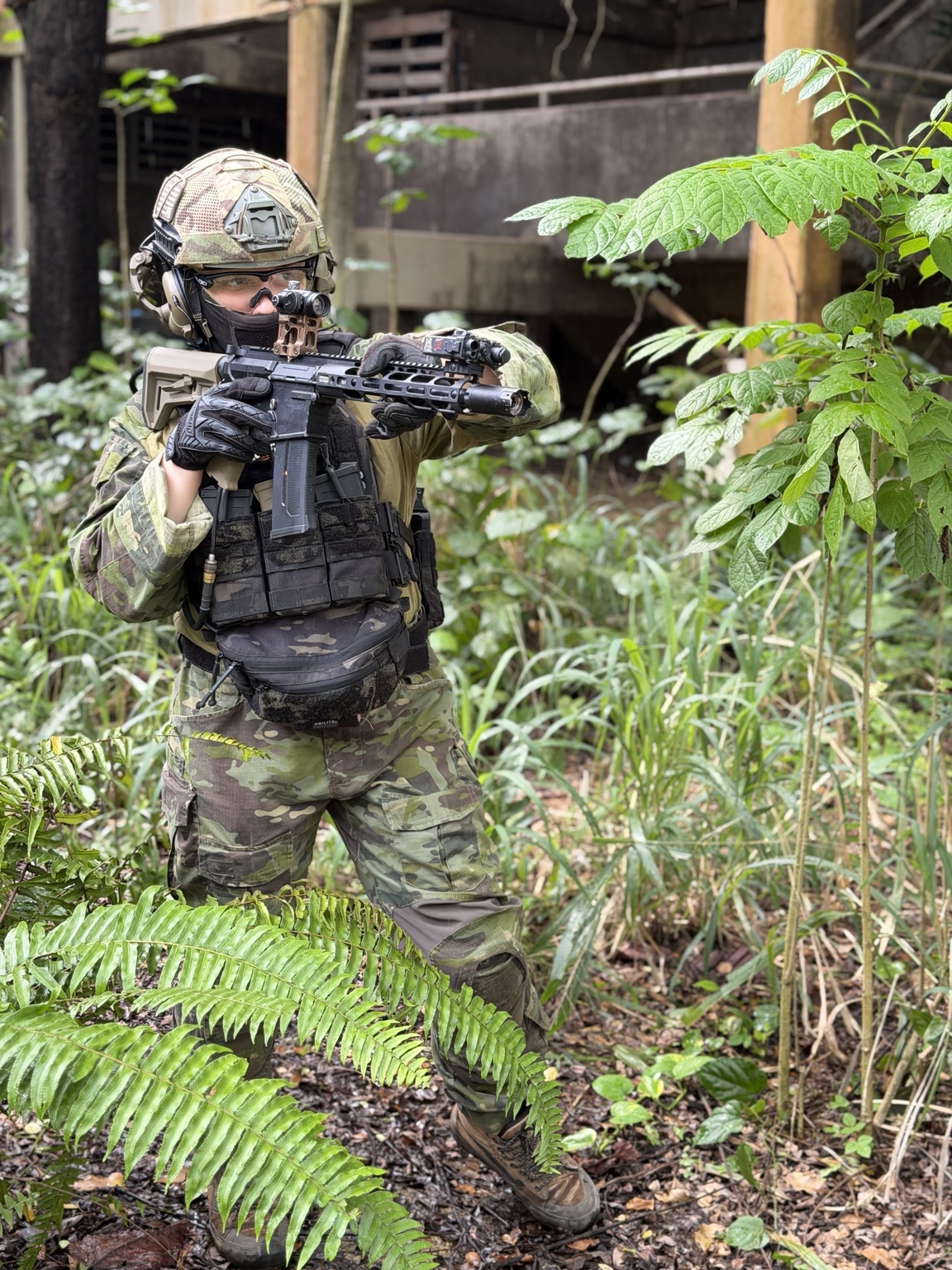 Jugador de airsoft con su réplica entre vegetación